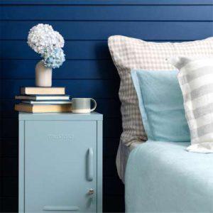 Der himmelblaue Mustard Made Shorty macht sich vor der dunkelblauen Wand wunderbar als Nachttisch.