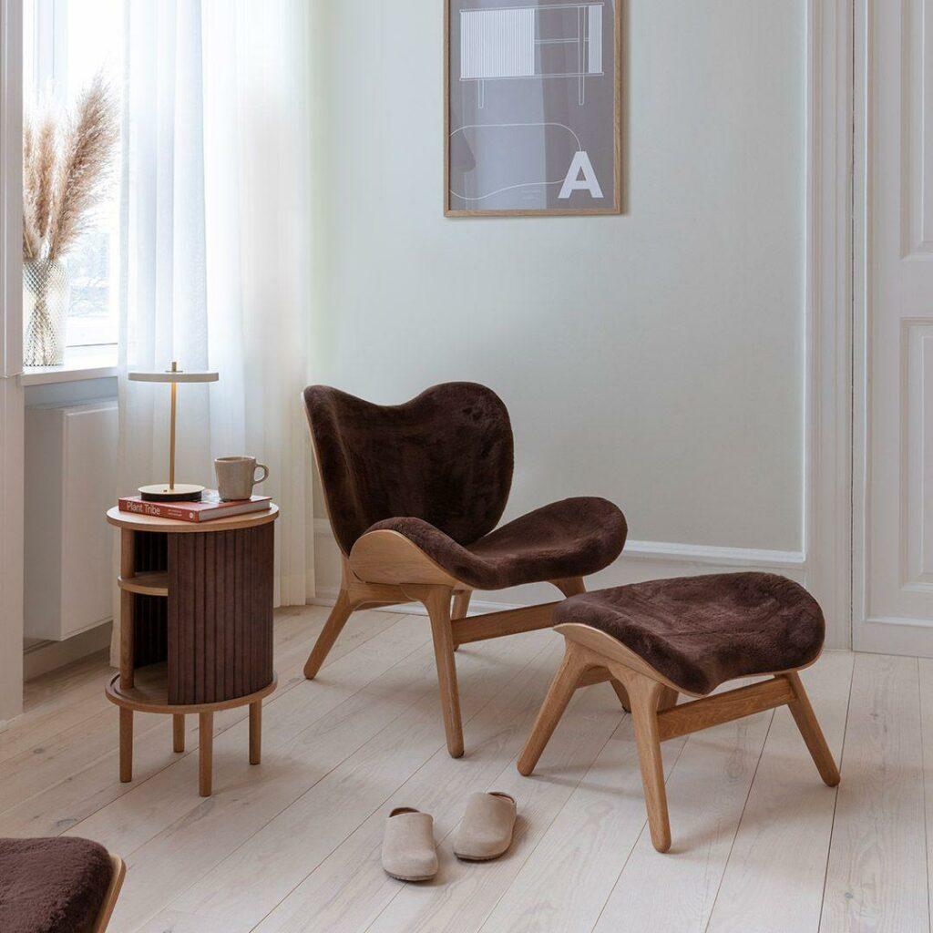 UMAGE A Conversation Piece Loungesessel als gemütlicher Rückzugsort. In dunklem Braun, mit Hocker für die Beine und auf alle Fälle einer der Interior Trends 2026. Echter New Scandi-Style!