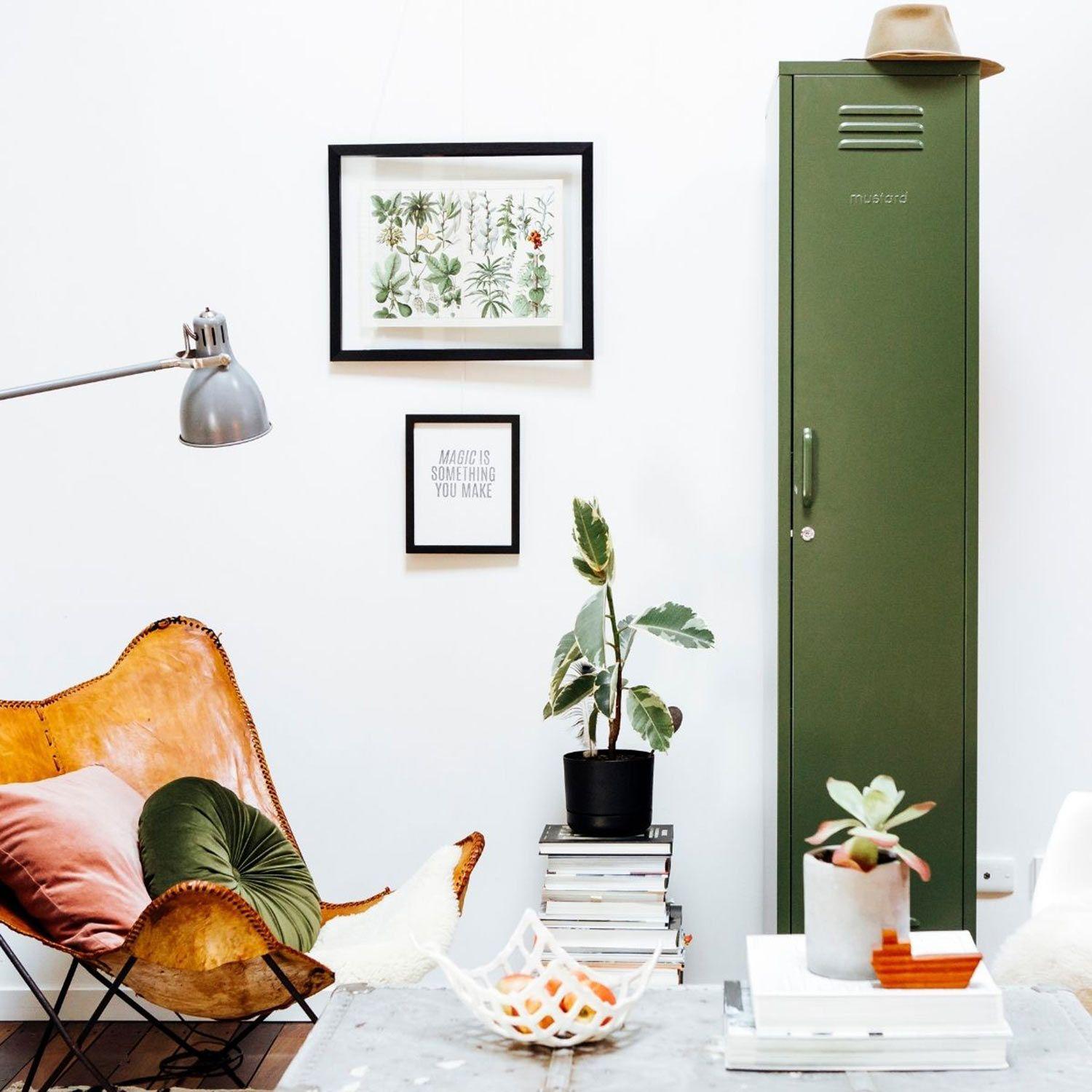 Frühlingshafte Farben im Zuhause in einem stylischen Wohnzimmer: Butterfly Sessel mit bunten Kissen, Tisch mit Obstschale und Mustard Made Spindschrank.