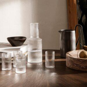 7 frische Ideen für ein Frühstück im Freien 3 Ferm Living Ripple Karaffe Glas und vier Ripple Verrines Gläser auf einem Holztisch neben einem dunklen Krug