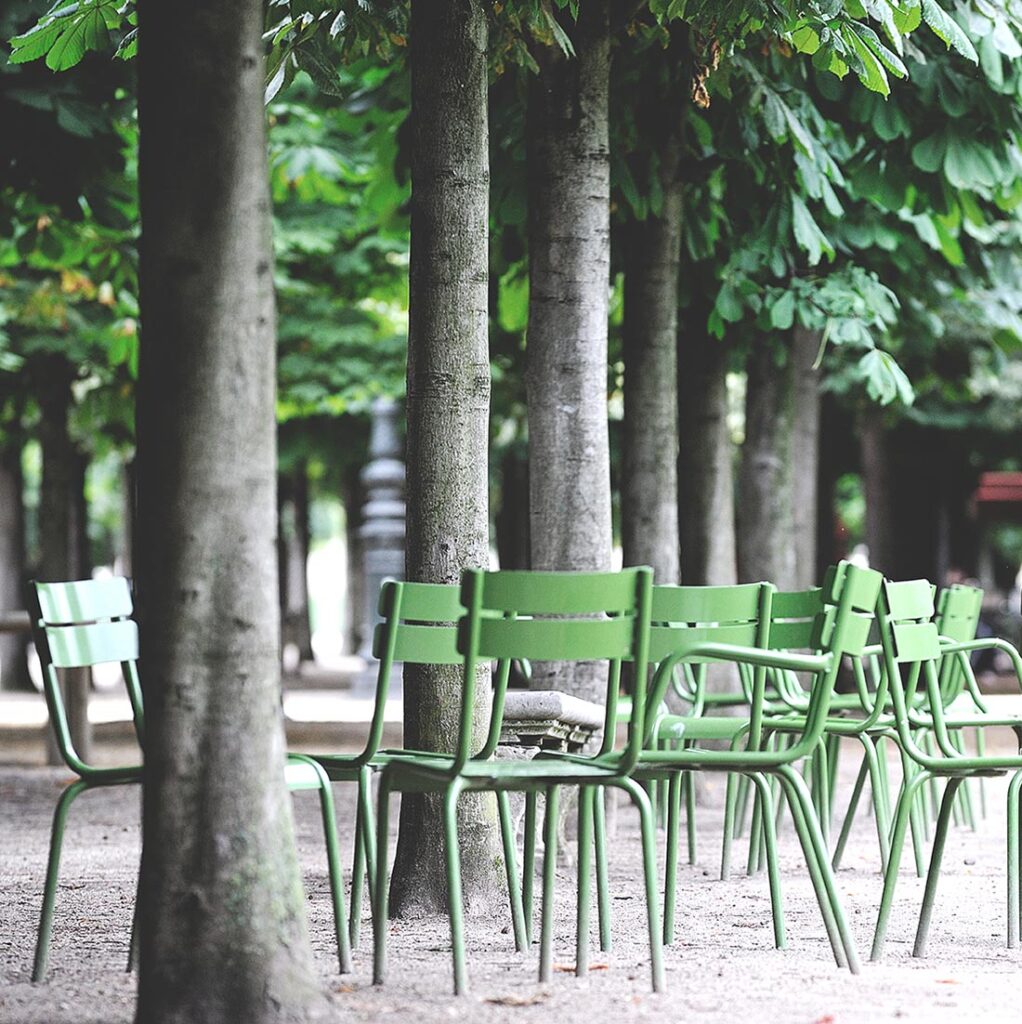 Grüne Fermob Luxembourg Stühle in einem Park. 