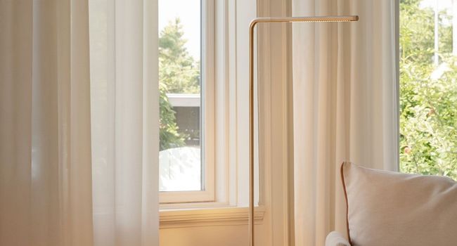 UMAGE Stehlampe Omni Stehleuchte neben Sessel