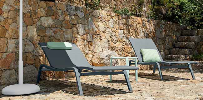Liegestühle & Liegen Fermob Alizé XS Sonnenliege in grau unter einem grünem Sonnenschirm