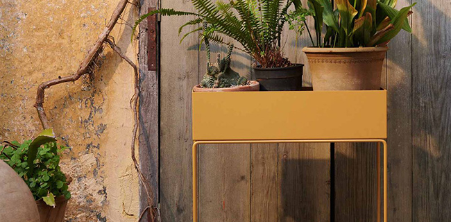 Ferm Living Plantbox gelb draußen mit Blumen